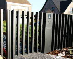 Open hekwerk poort met brievenbusconsole in zwarte structuurlak.