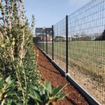 Zwart palen systeem met onderplaat voorzien van pantanet Family draad. Afgewerkte hoogte +/- 1.90 meter.